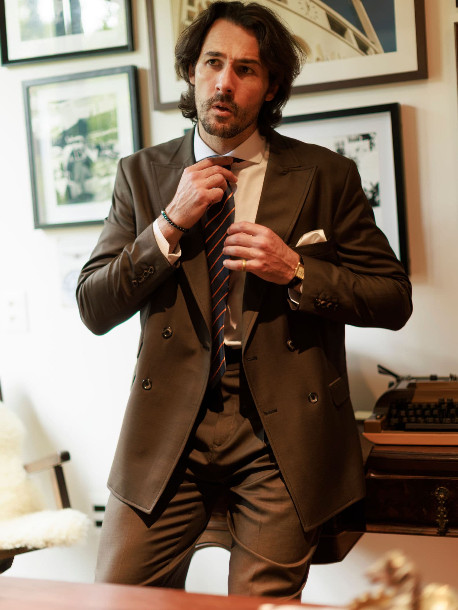 Buttoned brown double-breasted jacket before framed pictures